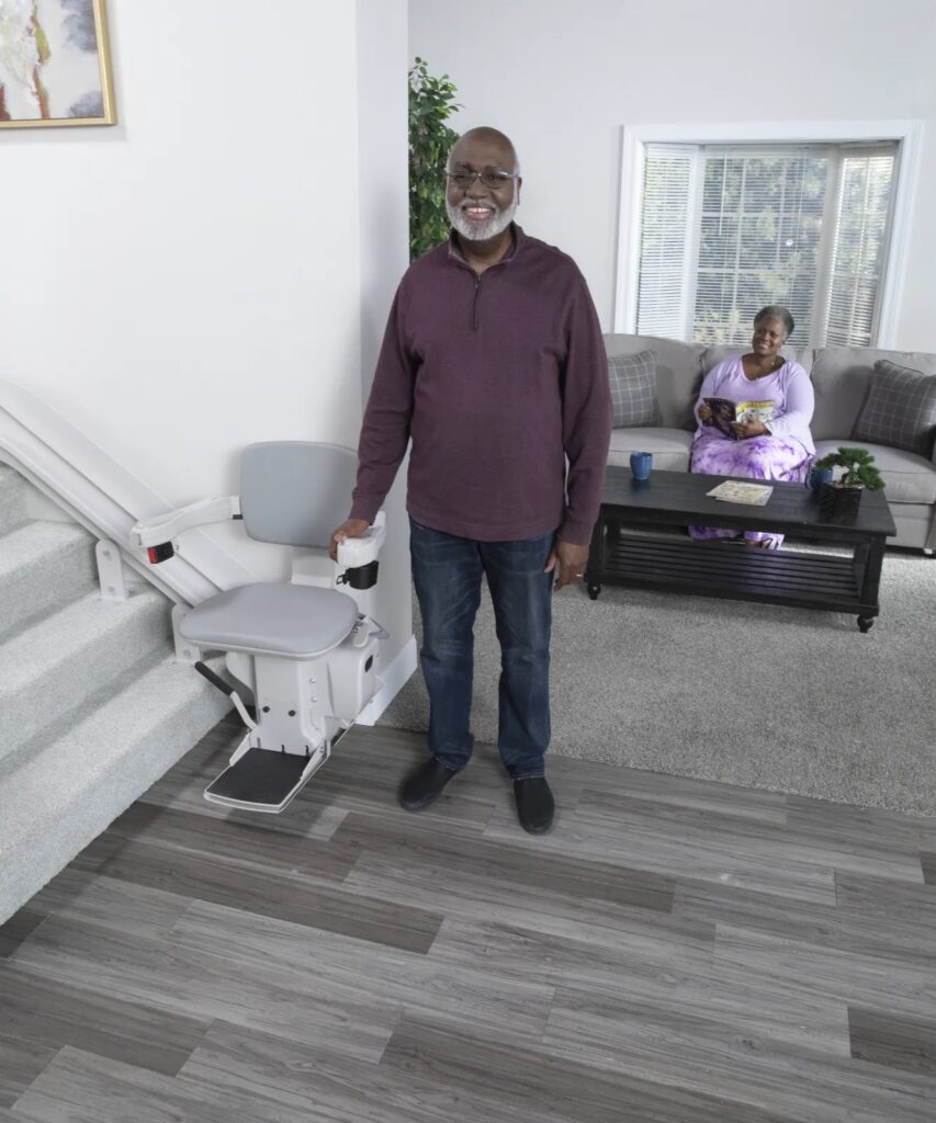 A man standing in front of a couch with a lift.