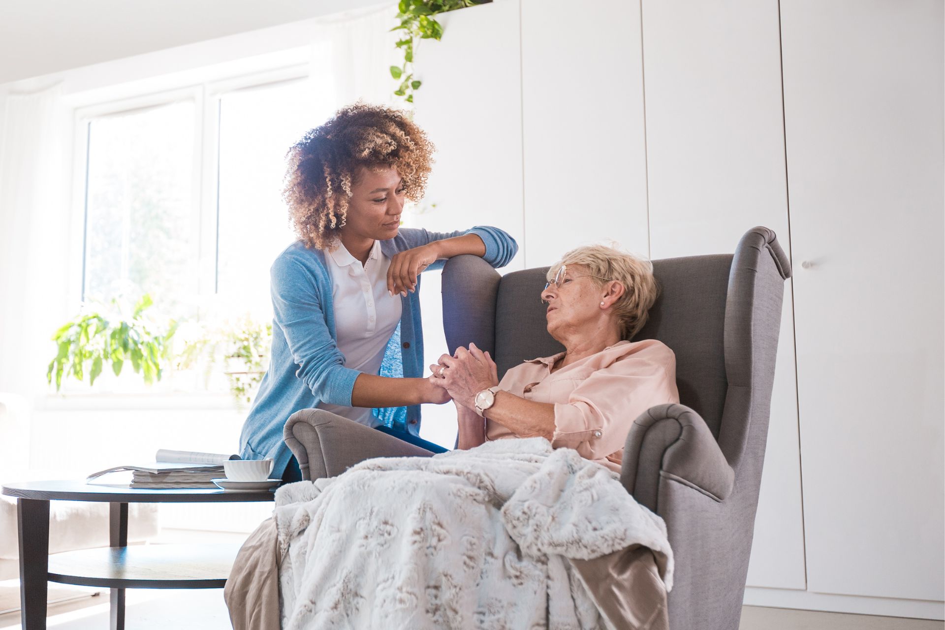 A woman sitting in a chair with an older person.